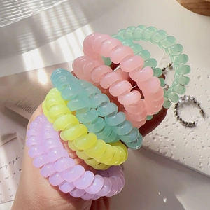 Close-up of pastel macaron spiral hair ties in matte resin finish with soft window light