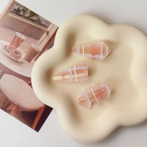 Détail de pinces à cheveux à carreaux rose pastel sur un plateau en céramique