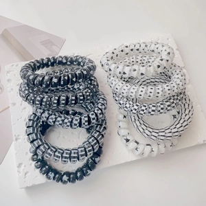 Macro shot of black and white spiral hair ties with classic heart and star patterns