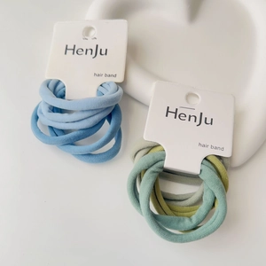 Detail of high-elasticity fabric hair bands in blue and green sets on a ceramic plate