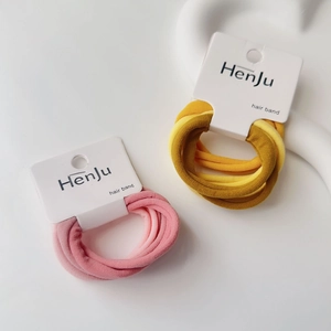 Detail of pink and yellow plush elastic hair bands on branded display cards
