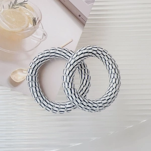 Close-up of black and white striped spiral telephone wire hair ties on magazine
