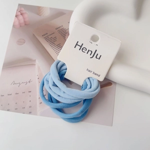 Detailed macro view of blue high-elasticity hair ties on minimalist card packaging