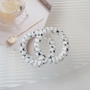 Detail of spiral hair ties with black stars print on translucent white elastic coils