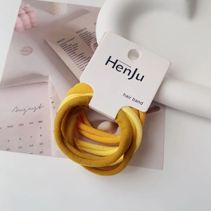 Detail of high-elastic towel hair ties in yellow gradient colors on card packaging