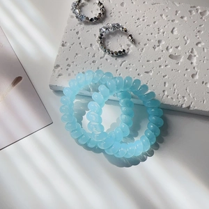 Close-up of light blue spiral hair ties and silver geometric rhinestone earrings set