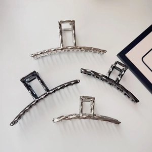 Detailed view of silver and gun black metal hair claws with irregular hammered texture
