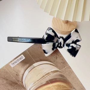 Macro detail of cow print acetate bow hair clip showing France Handmade engraving