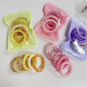 Close-up of colorful gradient spiral telephone wire hair ties with star patterns