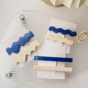Details von blauen und beigen Acetat-Haarspangen auf Displaykarte mit Goldbuchstaben