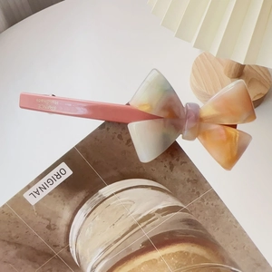 Detailed view of pink acetate bow hair clip with marble texture and France Handmade stamp