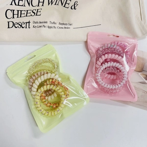 Candy gradient spiral hair ties in yellow and pink sets on a white background