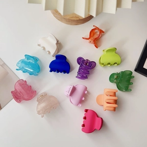 Macro shot of colorful matte mini hair clips set on a clean white table background