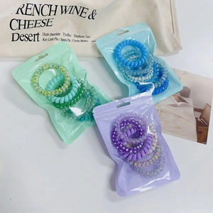 Detail of colorful gradient spiral hair ties in pastel green, blue and purple pouches
