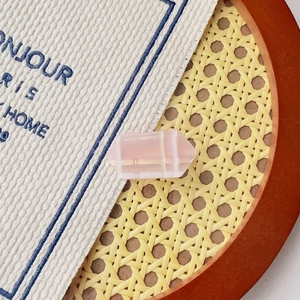 Barrette à cheveux rose avec prisme hexagonal sur fond de natte en paille tressée