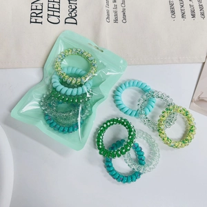 Set of colorful spiral telephone cord hair ties in a mint green frosted zipper pouch