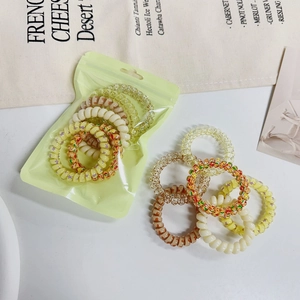 Macro shot of colorful spiral hair ties in cream and brown with a matte zipper bag