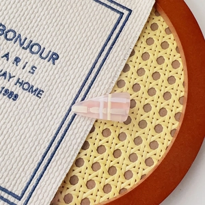 Détail de la pince à cheveux à carreaux rose sur tissu avec finition résine