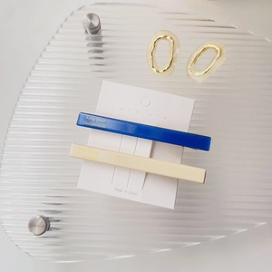 Detail von blauen und beigen Acetat-Haarspangen mit Amy-Bär-Logo auf einer Displaykarte