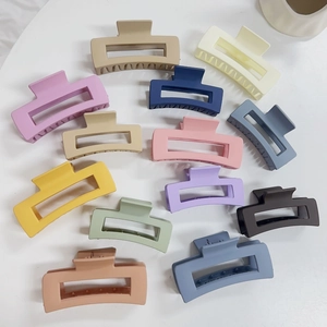 Vista piatta di tredici mollette per capelli rettangolari opache in vari colori macaron