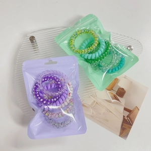 Detail view of colorful gradient spiral hair ties in frosted zipper packaging bags