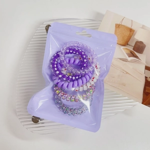 Detail of colorful spiral hair ties in a frosted purple pouch on a stylish tray