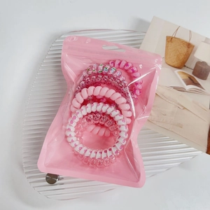 Pink spiral hair ties set with heart and flower patterns in a translucent zipper pouch