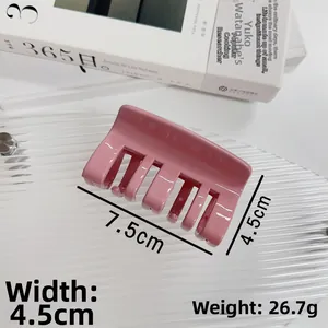 Vue détaillée de la pince à cheveux rose mesurant 7,5 cm par 4,5 cm sur plateau verre