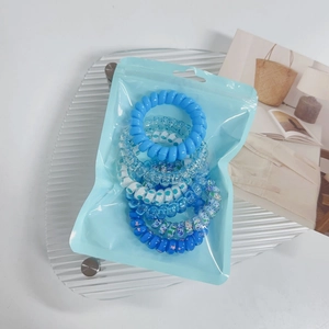 Detail view of blue gradient spiral hair ties in a clear pouch on a glass tray