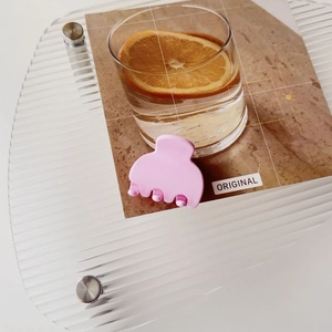 Close-up of a matte pink small hair claw clip with a rounded multi-tooth design for styling