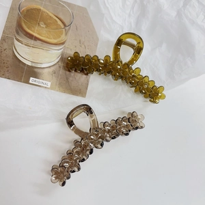Detail of jelly-colored flower hair claws in amber olive green and champagne grey resin