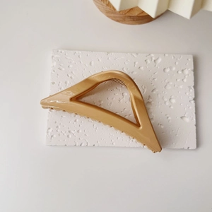 Vue détaillée de la pince à cheveux triangulaire creuse couleur caramel sur pierre