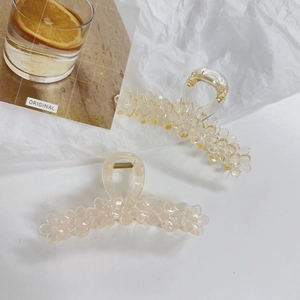 Detail of jelly yellow and cream white flower hair claws on aesthetic paper backdrop