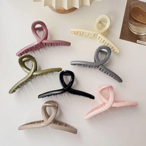 Set of large matte hair claws in 7 colors including olive green and pink on white surface