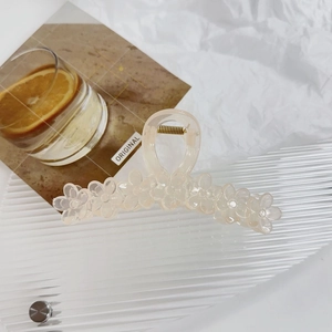 Detail of elegant large jelly pink flower hair claw clip with golden metal spring