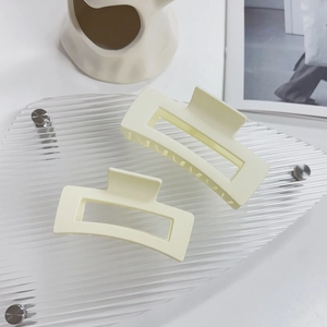 Dettagli macro delle pinze per capelli rettangolari color crema con denti antiscivolo