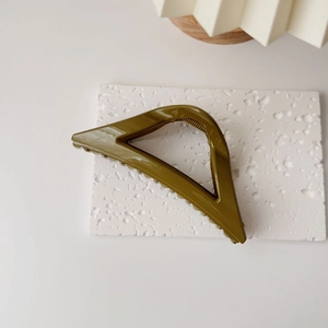 Vue détaillée de la pince à cheveux triangle vert olive avec fini brillant et dents