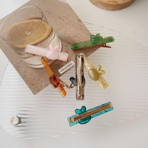 Détail de barrettes lapin en acétate coloré sur plateau en verre avec base dorée
