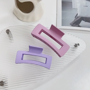 Dettaglio di due mollette per capelli rettangolari opache in rosa e viola chiaro