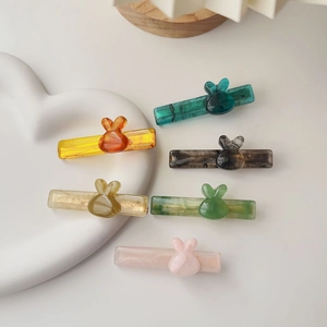 Détail de six barrettes à cheveux en résine colorée avec motif lapin sur fond blanc