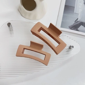 Dettaglio di fermagli per capelli rettangolari rosa arancio opaco con design geometrico moderno