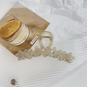 Detail of jelly colored flower claw clip with polished amber finish and metal spring