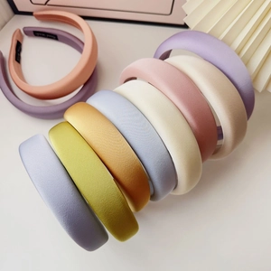 Detail showing various colors of thick sponge headbands with handmade woven labels