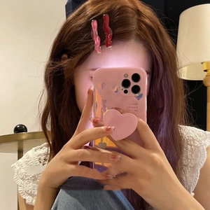 Pink and burgundy wavy acrylic hair clips on model in a warm indoor setting