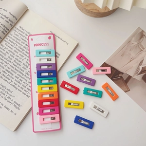 Detailed set of ten colorful square matte hair clips for children on a pink card