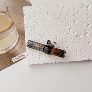 Détail d'une barrette en écaille ambrée avec motif lapin mignon sur fond blanc