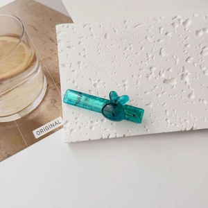 Détail de la pince à cheveux en acrylique bleu avec motif de lapin mignon sur fond blanc