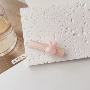 Détail d'une pince à cheveux rose marbrée avec une décoration tête de lapin mignonne