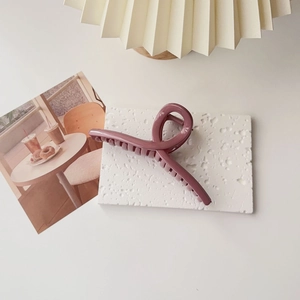 Detail of matte dusty purple large hair claw clip with double-row teeth on white texture board