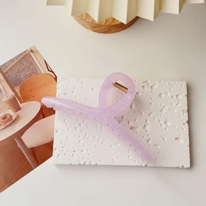 Detail of lavender oversized hair claw clip made of resin on a textured white stone